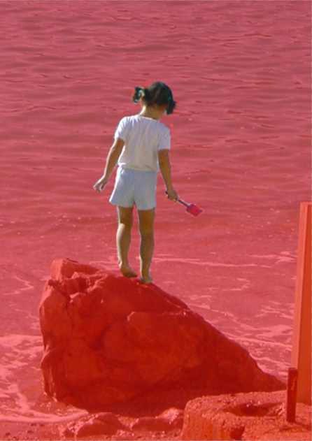 Image of the girl on the beach with the red Quick Mask overlay covering everything but the girl.
